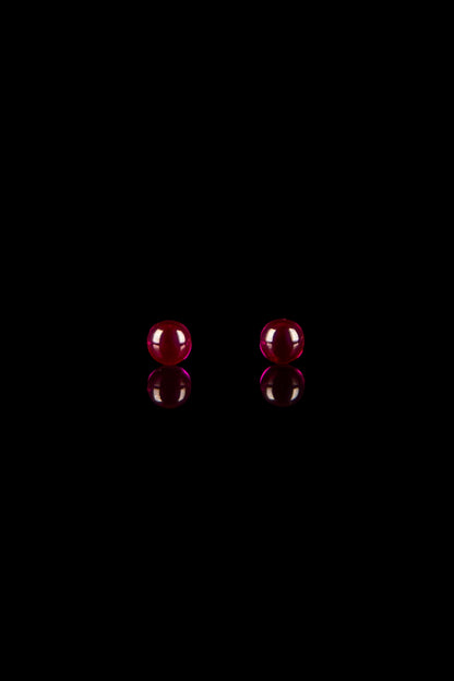 Red glass cannabis bubblers on black background.