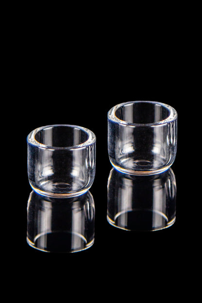 Two clear quartz banger buckets with reflections on a black background.