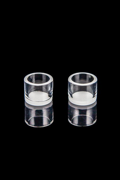 Two clear quartz bongs against a black background.