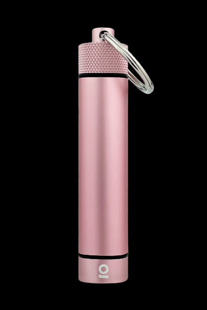 Pink metal cannabis oil vape pen with a keyring attached, isolated on a black background.