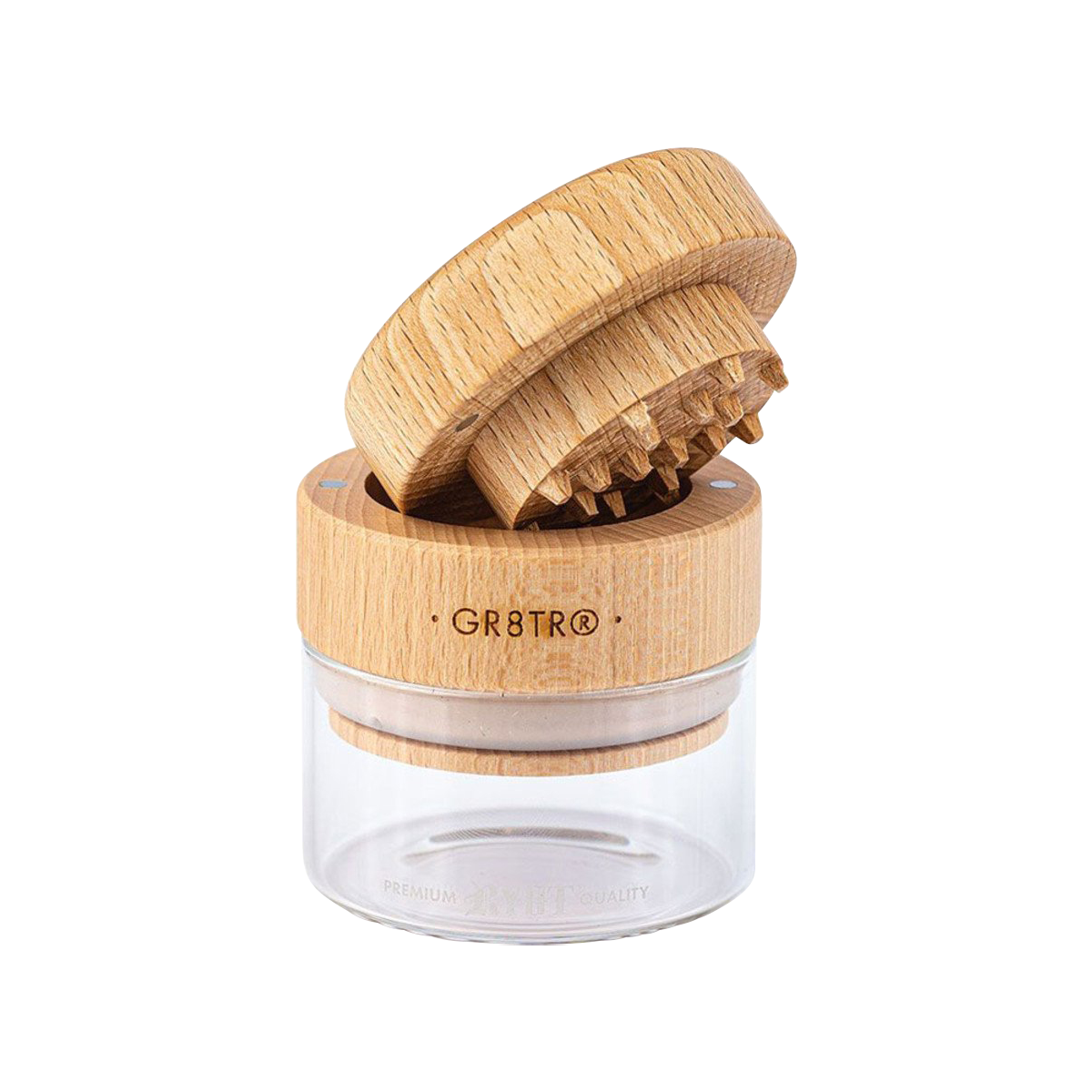 A close-up, top-down view of the RYOT Beech Wood GR8TR Grinder with Glass Jar, showing its textured wood lid and clear glass base.