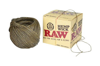 A close-up of the RAW Hemp Wick Ball, a tightly wound spool of natural fiber cord against a branded cardboard backing.