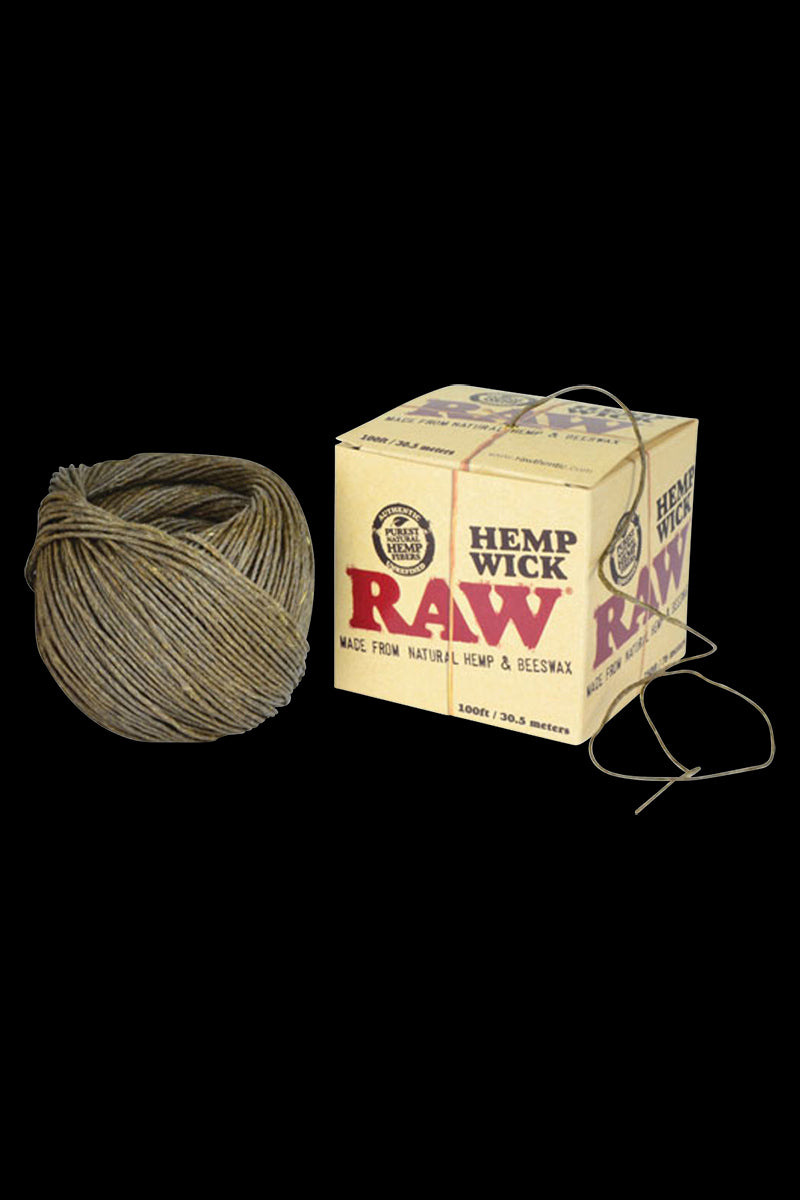 A close-up of the RAW Hemp Wick Ball - 100ft, showing a tightly wound coil of natural fiber wick against a dark background.