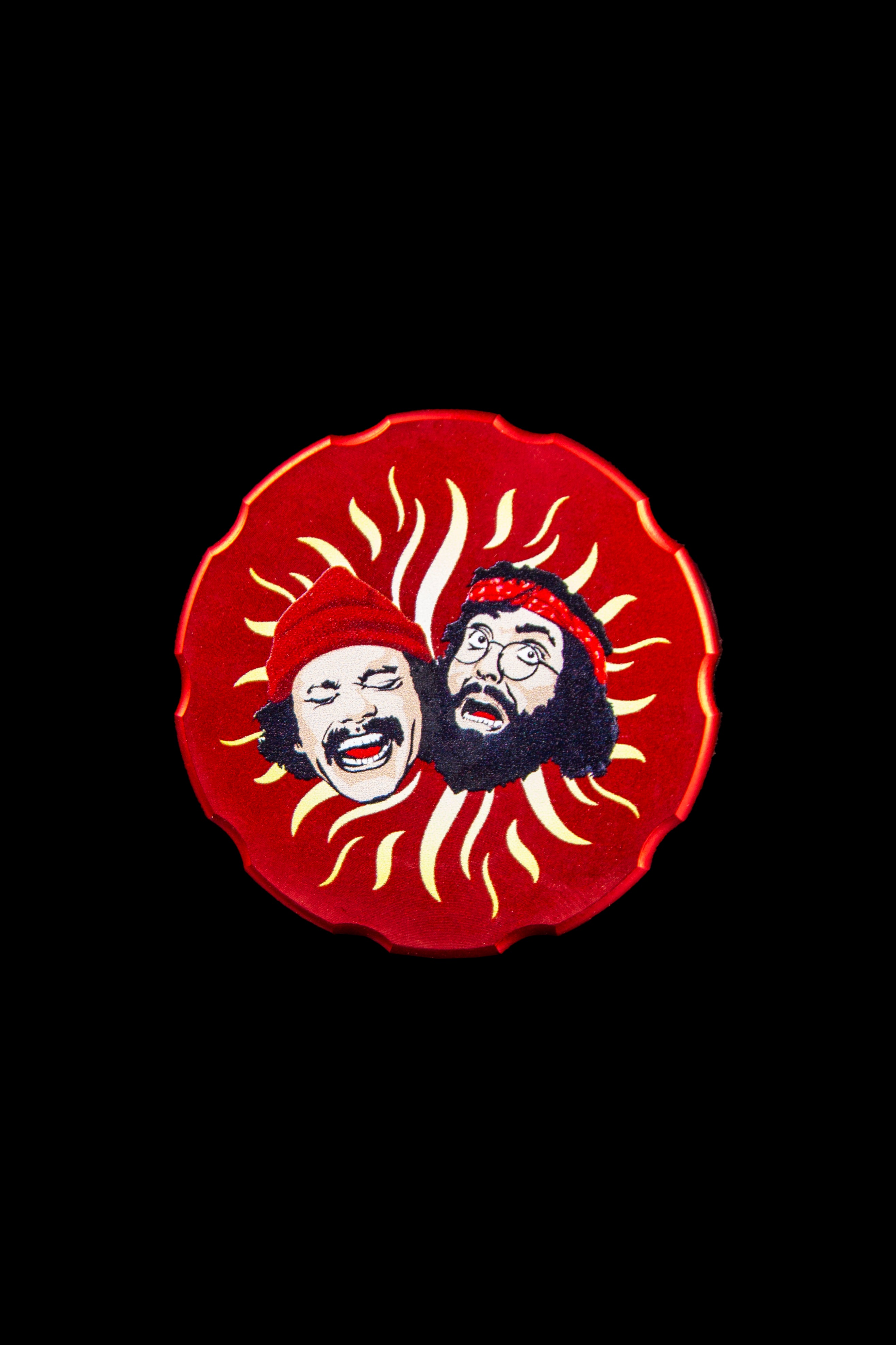Red circular patch featuring stylized portraits of Tommy Chong and Cheech Marin with sunburst rays, referencing the iconic cannabis comedy duo.
