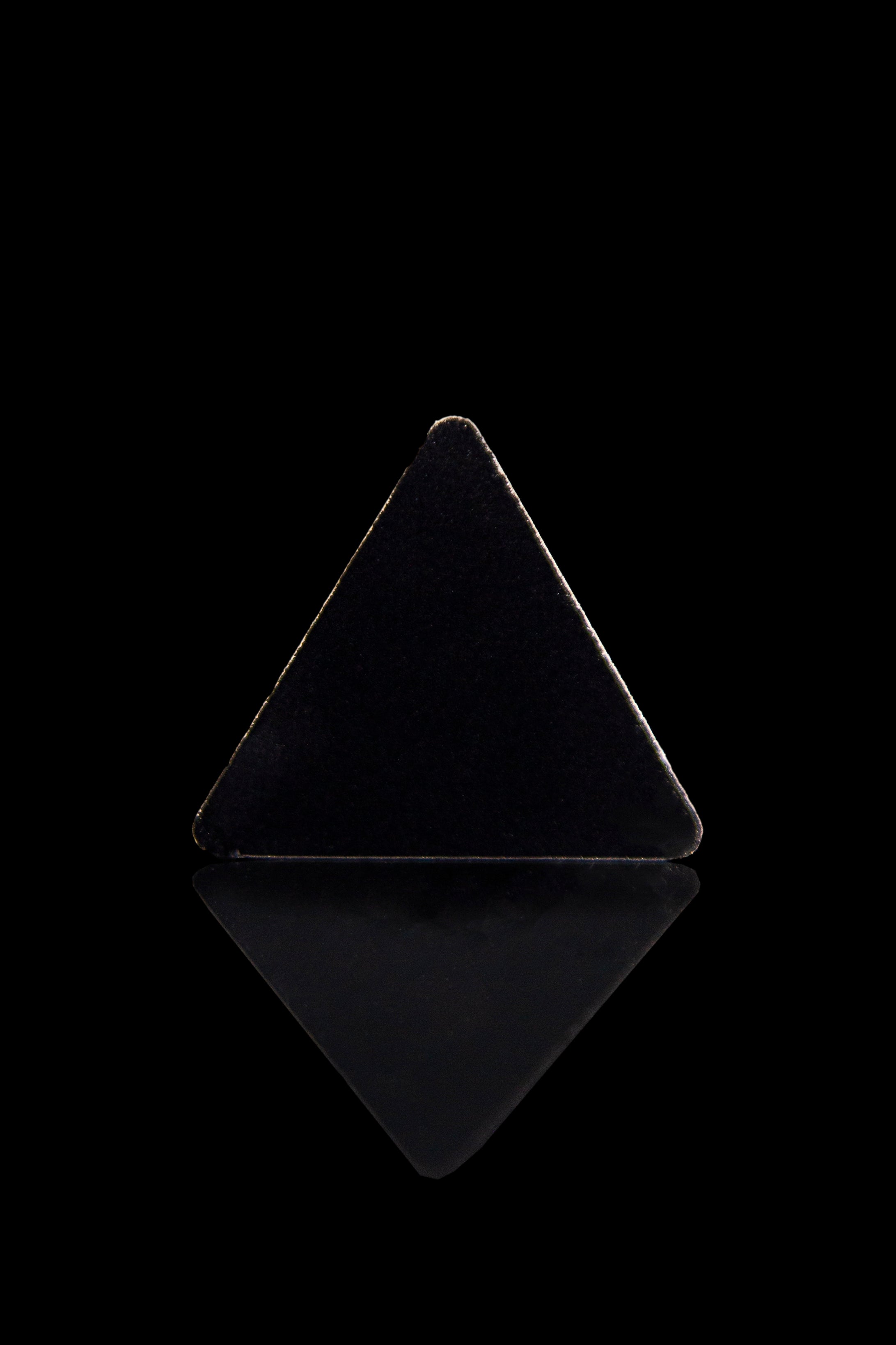 Black glass cannabis pyramid with a mirrored reflection.