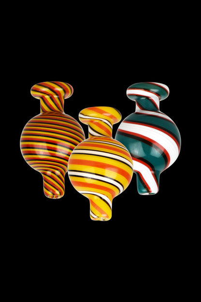 A close-up shot of the Reverse Color Glass Ball Carb Cap, showcasing its swirling, colorful glass design against a black backdrop.