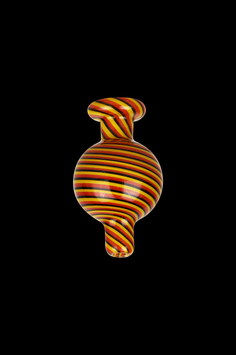 A vibrant, close-up view of the Reverse Color Glass Ball Carb Cap, showcasing its swirling red and yellow glass pattern.