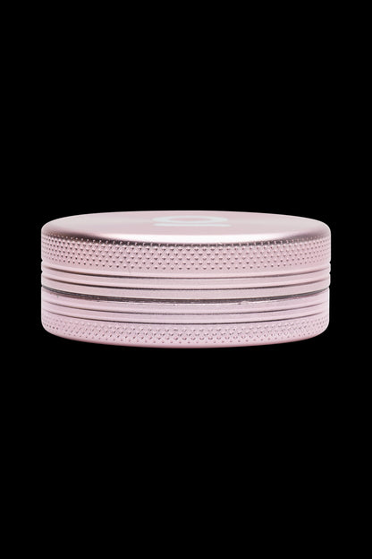 Rose gold cannabis grinder on a black background.