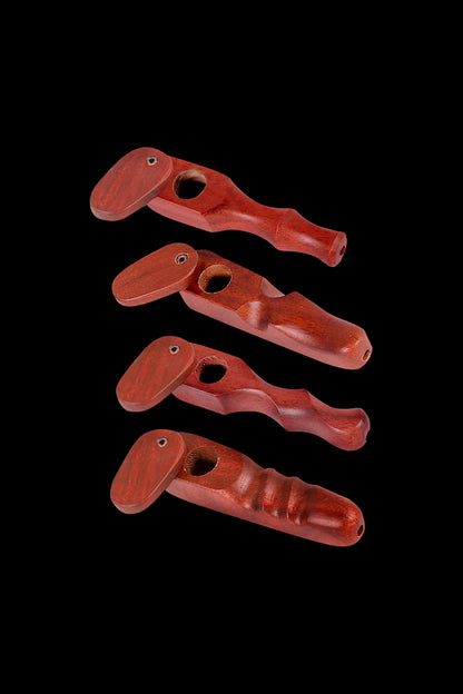 A side view of the Rosewood Spoon Pipe with Swivel Lid, showcasing its dark wood grain and curved design against a black background.