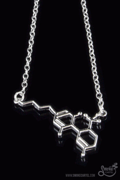 Close-up of the Smoke Cartel THC Molecule Bracelet, a silver-toned chain with a molecular structure pendant against a dark background.
