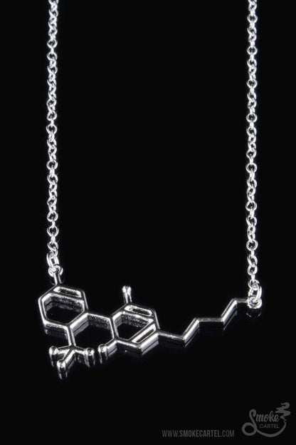 A close-up of the Smoke Cartel THC Molecule Necklace, a silver pendant resembling a molecular structure on a delicate chain.