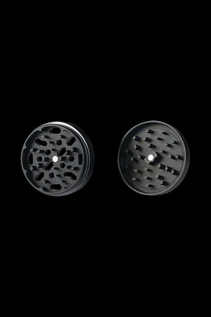 A close-up, top-down view of the Kannastor 4-Piece Solid Body Grinder showcasing its textured metallic finish and circular design.