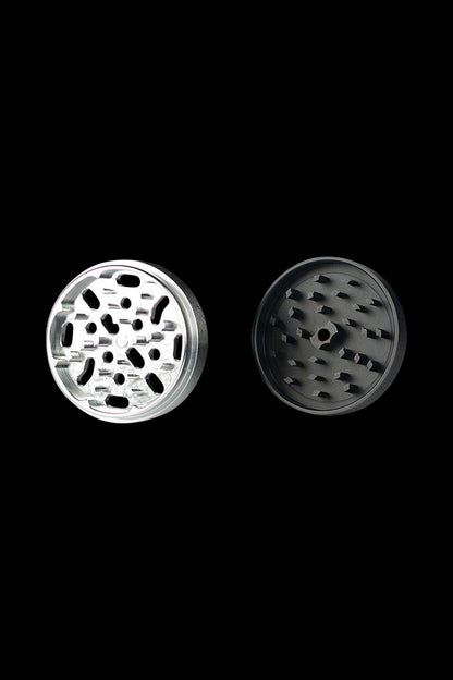 A close-up, top-down view of the Kannastor 4-Piece Solid Body Grinder, showcasing its metallic, multi-tiered design.