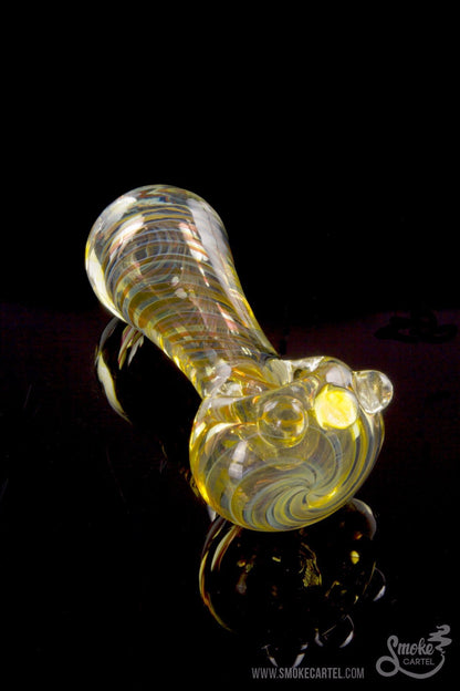 A side view of the Gold Fumed Spoon Pipe - Midas, featuring gold accents and a curved bowl against a dark backdrop.