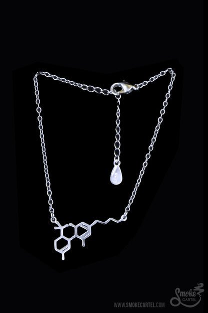 A close-up of the silver Smoke Cartel THC Molecule Bracelet, showcasing the detailed pendant against a blurred background.