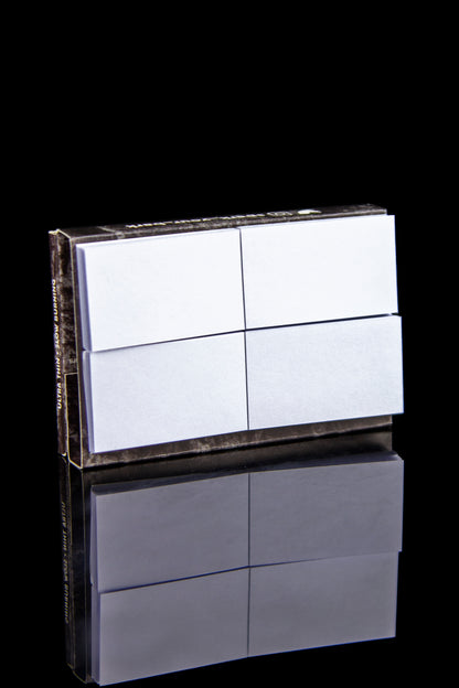 Stack of pre-rolled hemp filter tips with a mirrored reflection on a black surface.