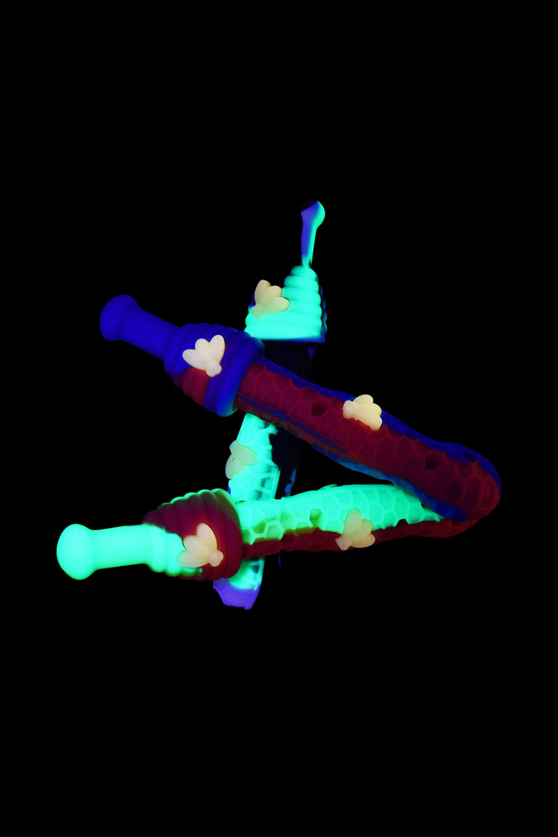 A slightly angled view of the Silicone UV Honeybee Vapor Straw with Cap, showcasing its colorful, translucent design against a dark background.