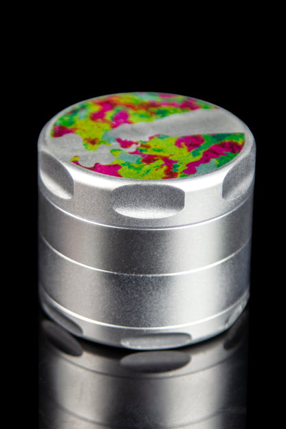 Silver cannabis grinder with a colorful, patterned top.