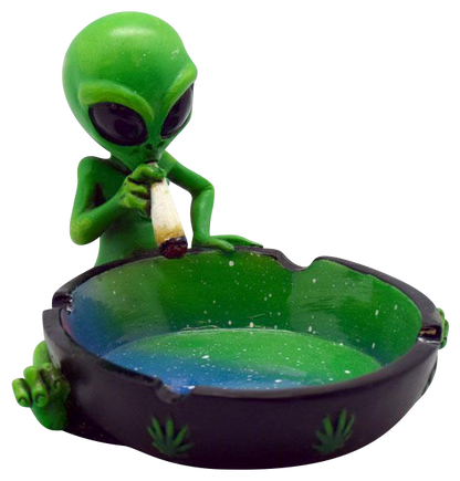 A detailed view of the Smoking Alien Ashtray, showing a green alien figurine holding a cigarette over a small, dark-colored ashtray.
