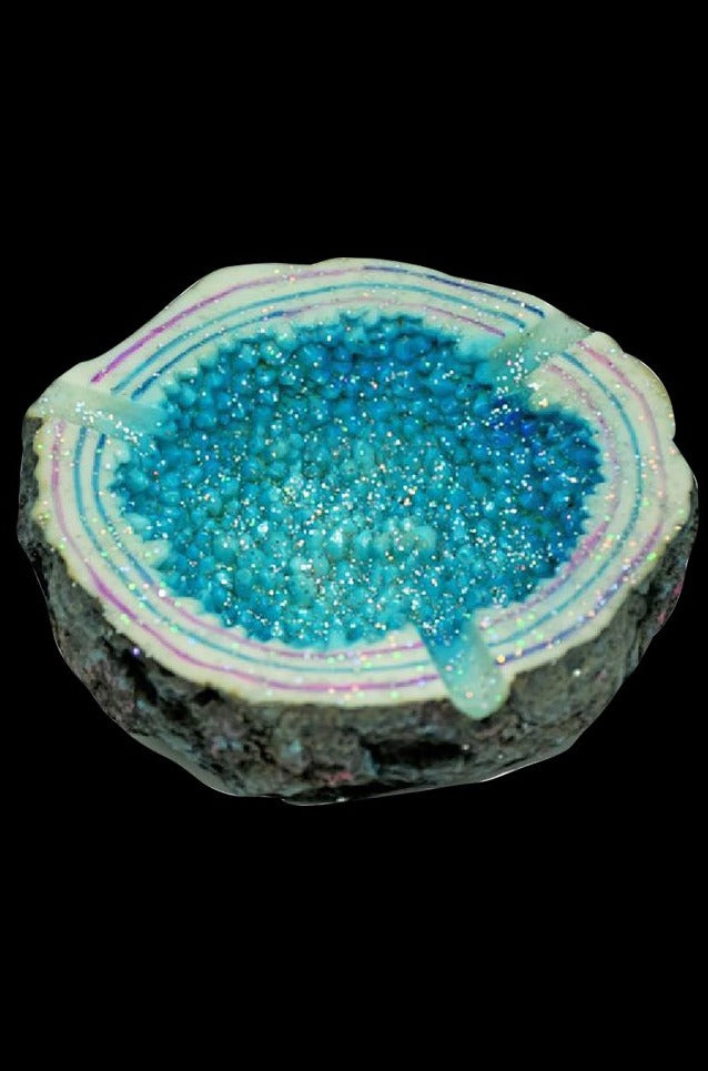 A close-up, top-down view of the Sparkling Geode Ashtray, displaying a textured, crystalline interior within a rough, natural stone edge.