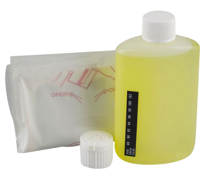 A front view of the 3.5oz Synthetix5 Fetish Urine bottle next to its open packaging, showing a clear plastic container.