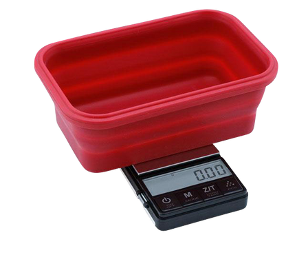A close-up, angled view of the Truweigh Crimson Collapsible Bowl Scale, displaying a digital readout on its small, red weighing platform.