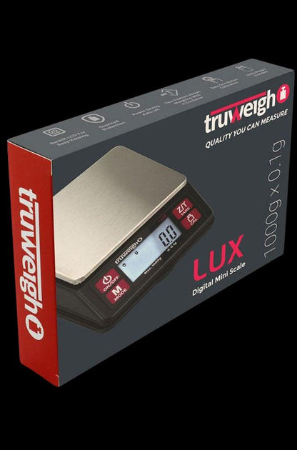 A close-up, angled view of the Lux Digital Mini Scale with a black face and silver body, displaying a digital readout.