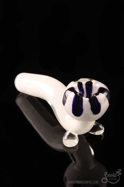 A studio shot displays the White Fritted Sherlock with Black 'Daisy' Fritted Bowl, with a patterned glass bowl and a curved pipe shape.