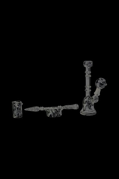 A close-up shot of the Glass Bell Dab Rig, showcasing the clear glass construction and angled mouthpiece from a low perspective.