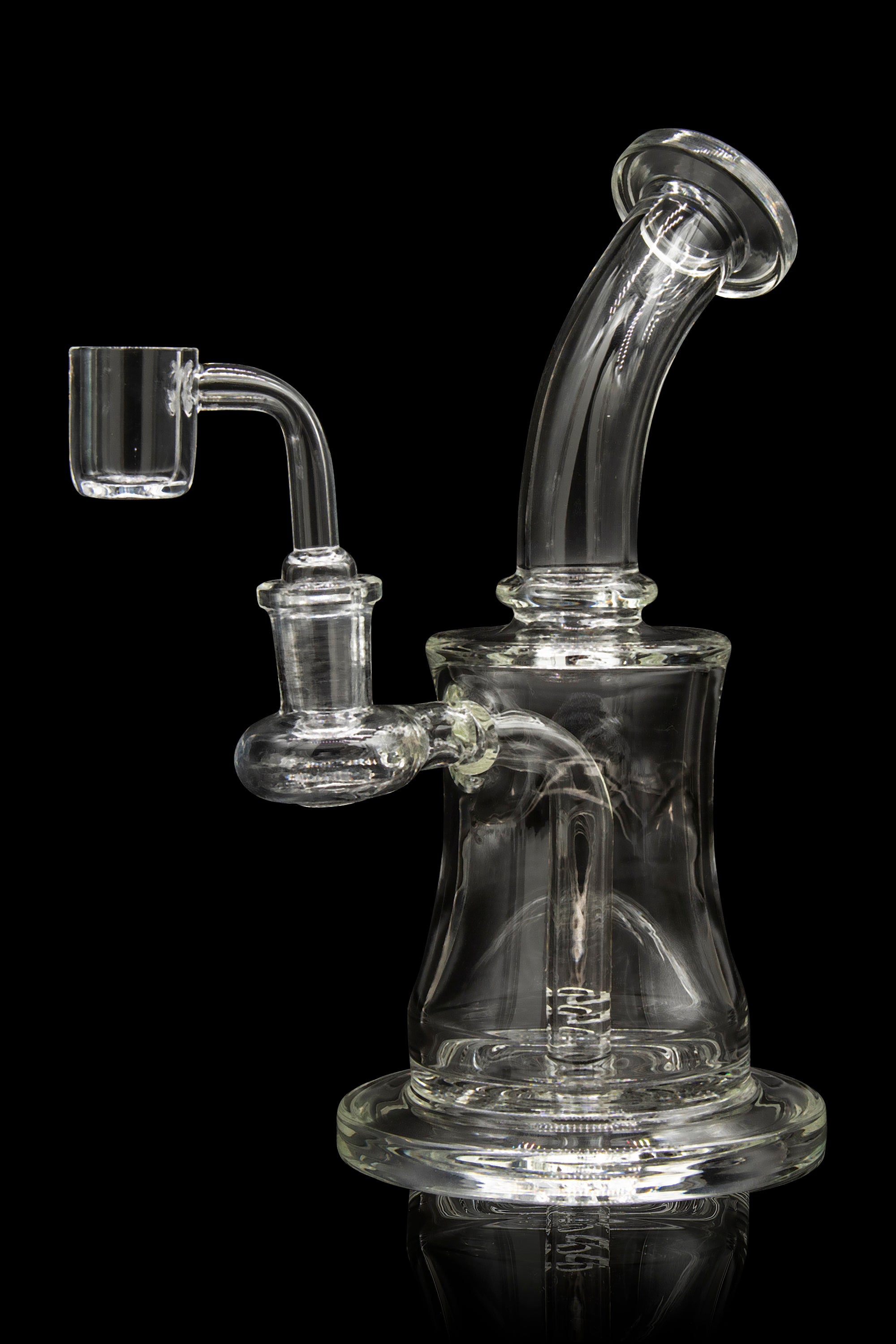 Clear glass dab rig with quartz banger, isolated on a black background.
