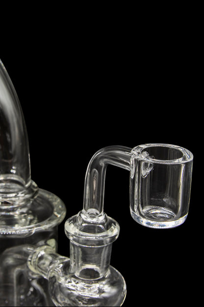 Clear glass dab rig with a quartz insert.