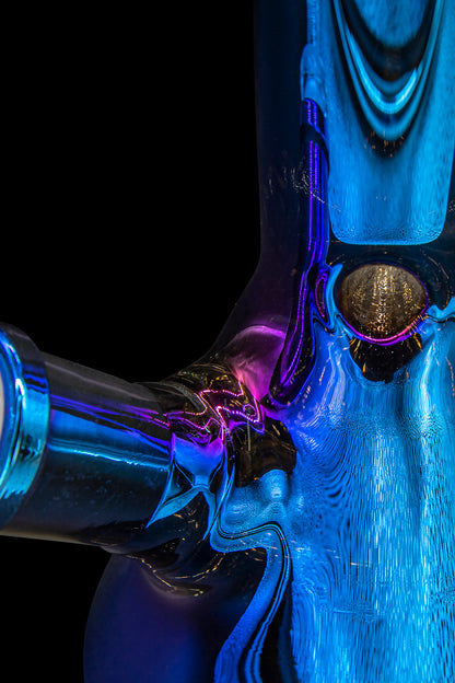 Abstract close-up of a glass cannabis pipe with vibrant blue and purple hues.