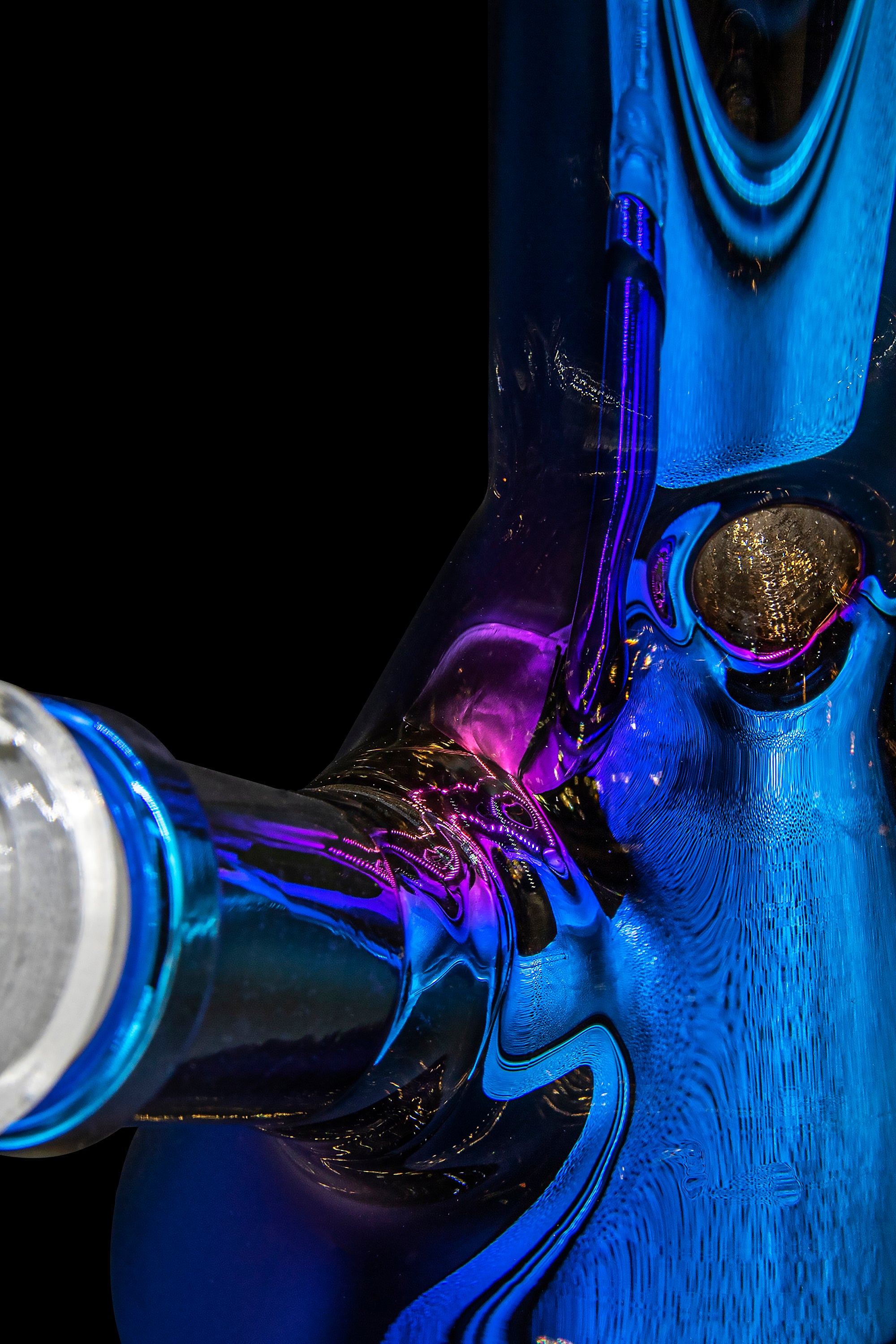 Close-up of a colorful, intricately designed glass water pipe against a black background.