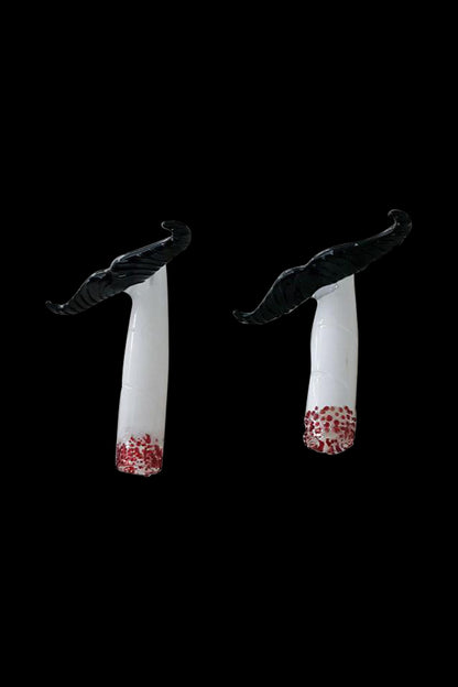 A studio shot of the Mustache Cig One Hitter, showcasing its clean lines and minimalist design against a stark black background.