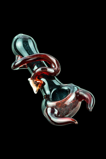 A close-up, angled view of the Little Devil Hand Pipe, showcasing its glossy, dark red finish and curved design.