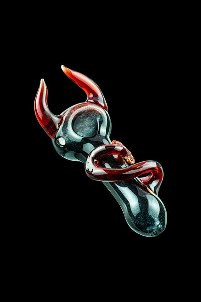 A close-up angled view of the Little Devil Hand Pipe, showcasing the sculpted, dark-colored glass design.