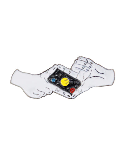 A close-up shows the Picture The Universe Enamel Pin held between two fingers against a plain white background.