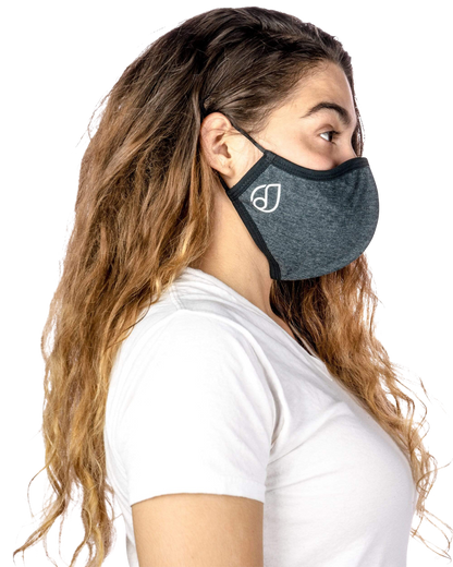 A woman wearing a Reversible Cloth Mask in a close-up, angled studio shot with soft lighting.