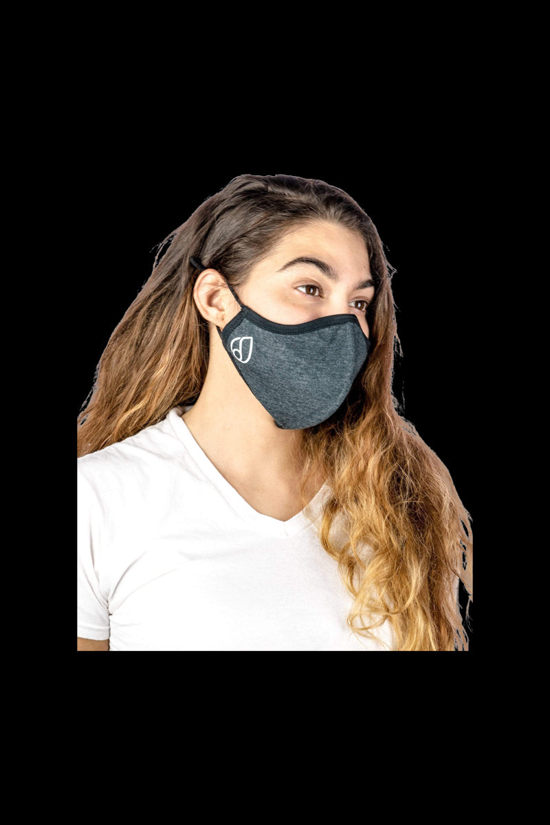 A woman wearing the Reversible Cloth Mask in a close-up, angled shot with soft, natural lighting.