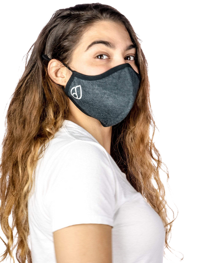 A woman wearing the Reversible Cloth Mask in a close-up, angled shot with soft lighting.