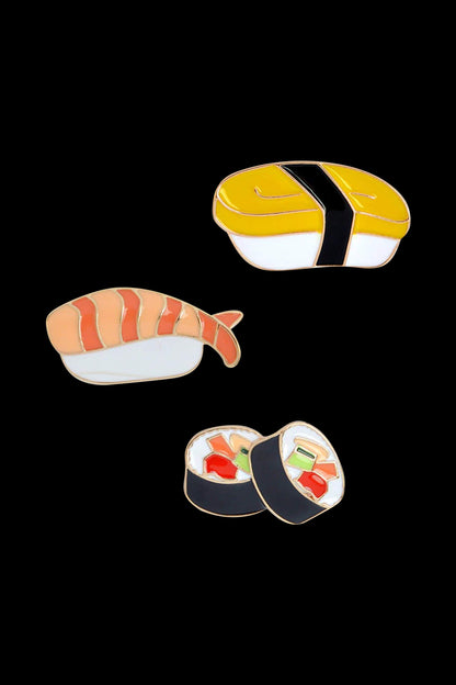 Overhead view of the Sushi Enamel Pin - 3 Pack, showcasing three colorful pins arranged against a plain white background.