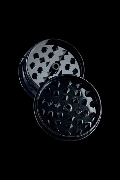 Close-up of the Travel Herb Grinder & Stash Jar, showing a silver metal grinder with a textured surface on a dark background.