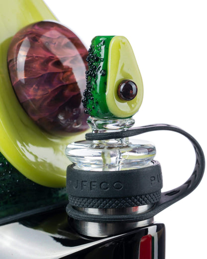 Close-up view of the Empire Glassworks Avocadope Carb Cap for Puffco Peak, showcasing its green, sculpted design against a blurred background.
