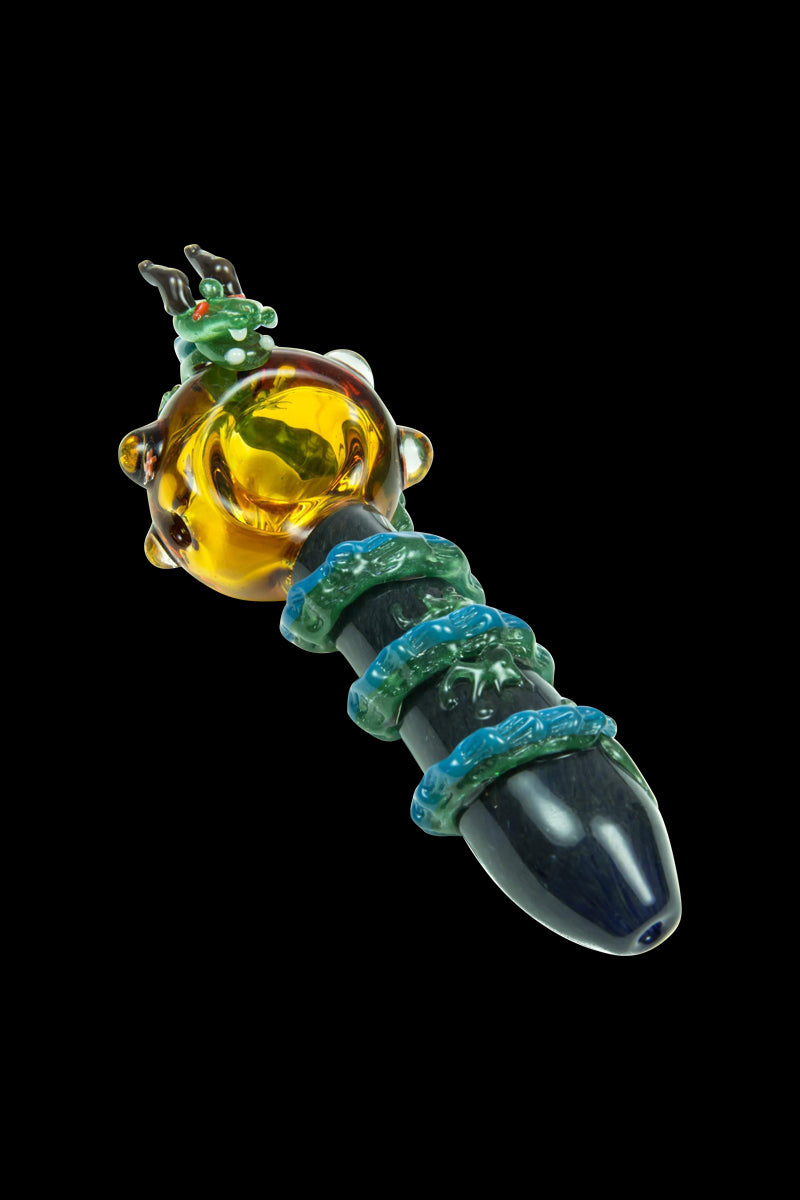 A close-up, angled view of the Empire Glassworks Dragon Sphere Small Spoon Pipe, showcasing its colorful, sculpted glass design.
