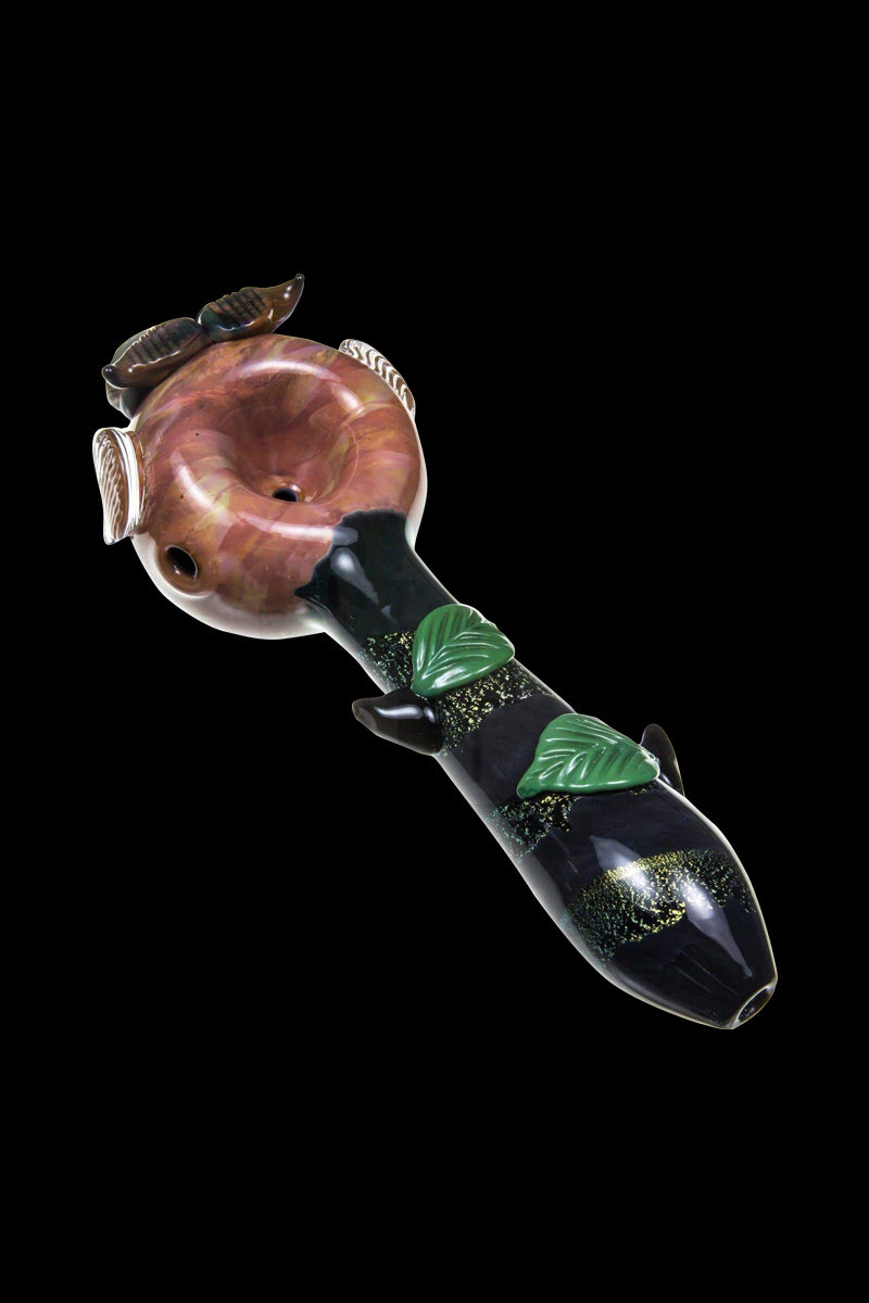 A side view of the Empire Glassworks "The Owl" Mini Glass Spoon Pipe, featuring sculpted details resembling an owl’s face.