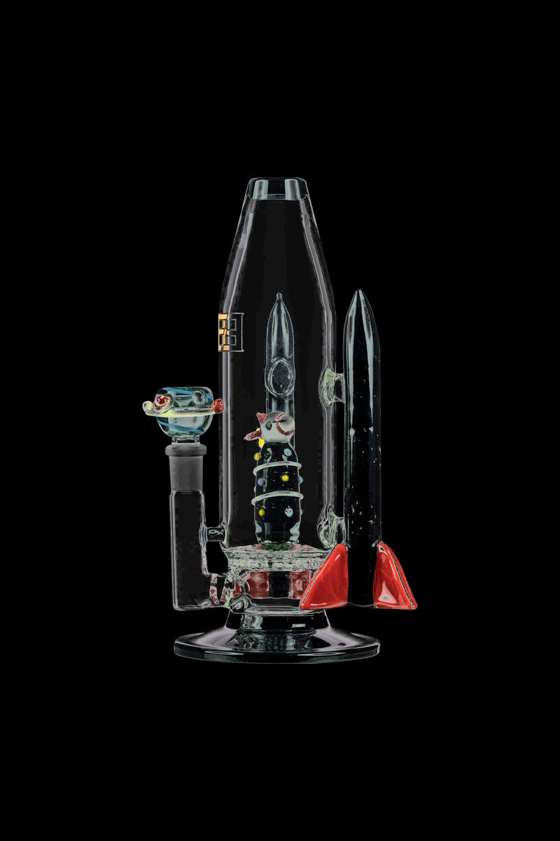A studio shot displays the Empire Glassworks Galactic Flagship Bong, a clear glass piece with a unique, spiraling design and colorful accents.