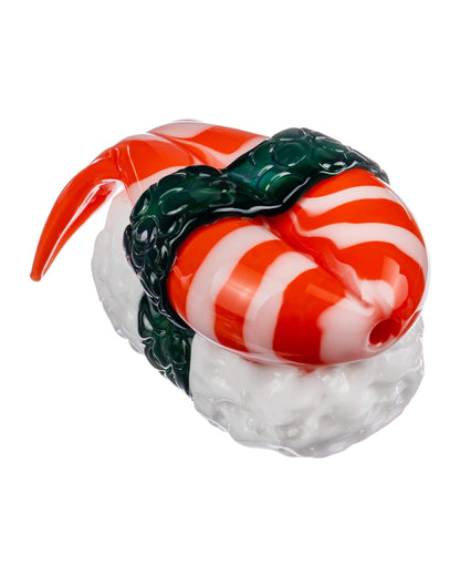 A studio shot of the Empire Glassworks Shrimp Nigiri Sushi Hand Pipe, showcasing its vibrant red and white design resembling sushi.
