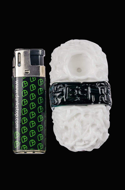 A close-up, angled view of the Empire Glassworks Spam Musubi Sushi Hand Pipe, resembling a miniature sushi roll.