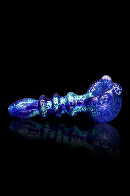 Blue glass pipe with swirling iridescent patterns, reflecting on a dark surface.