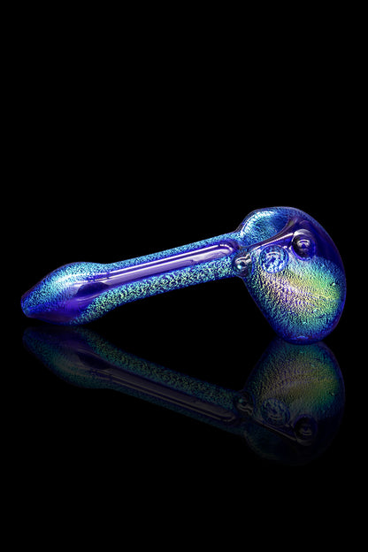 Iridescent glass pipe with a reflective surface, isolated on black.